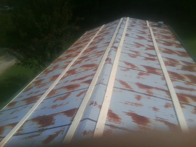Rusted metal roof panels with new wood purlins before replacement — Storm Damage Roof Repair in Salix by Roofing Brothers