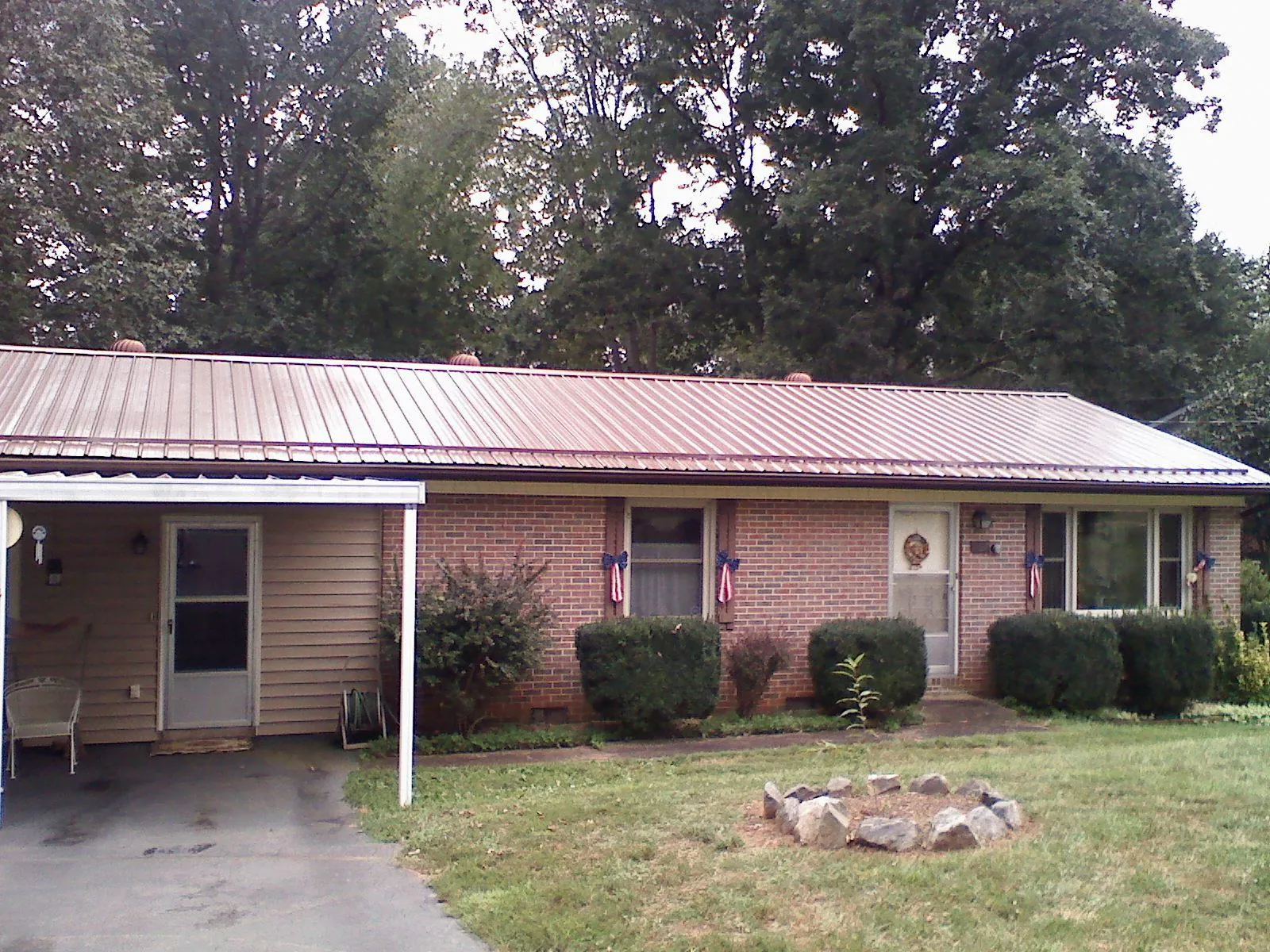 Bronze metal roof and carport on a brick ranch home — Roof Repair work by our crew in Salix